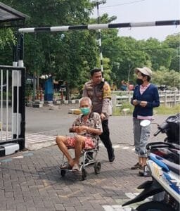 Layani Masyarakat Yang Ingin Mencoblos, Kapolsek Gunung Anyar Bantu Dorong Kursi Roda Seorang Lansia